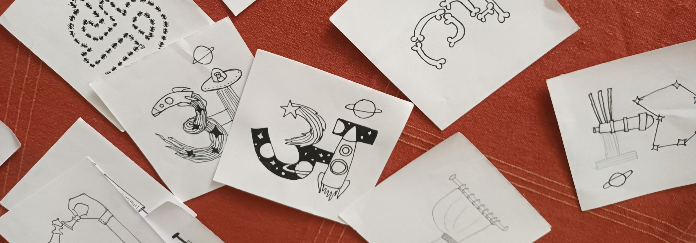 Akshar Chitra letterform postcards arranged on a warm surface