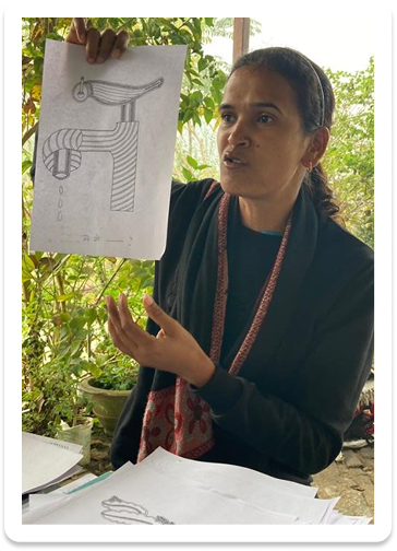 Teacher holding a letterform drawing of a tap integrated with a bird motif